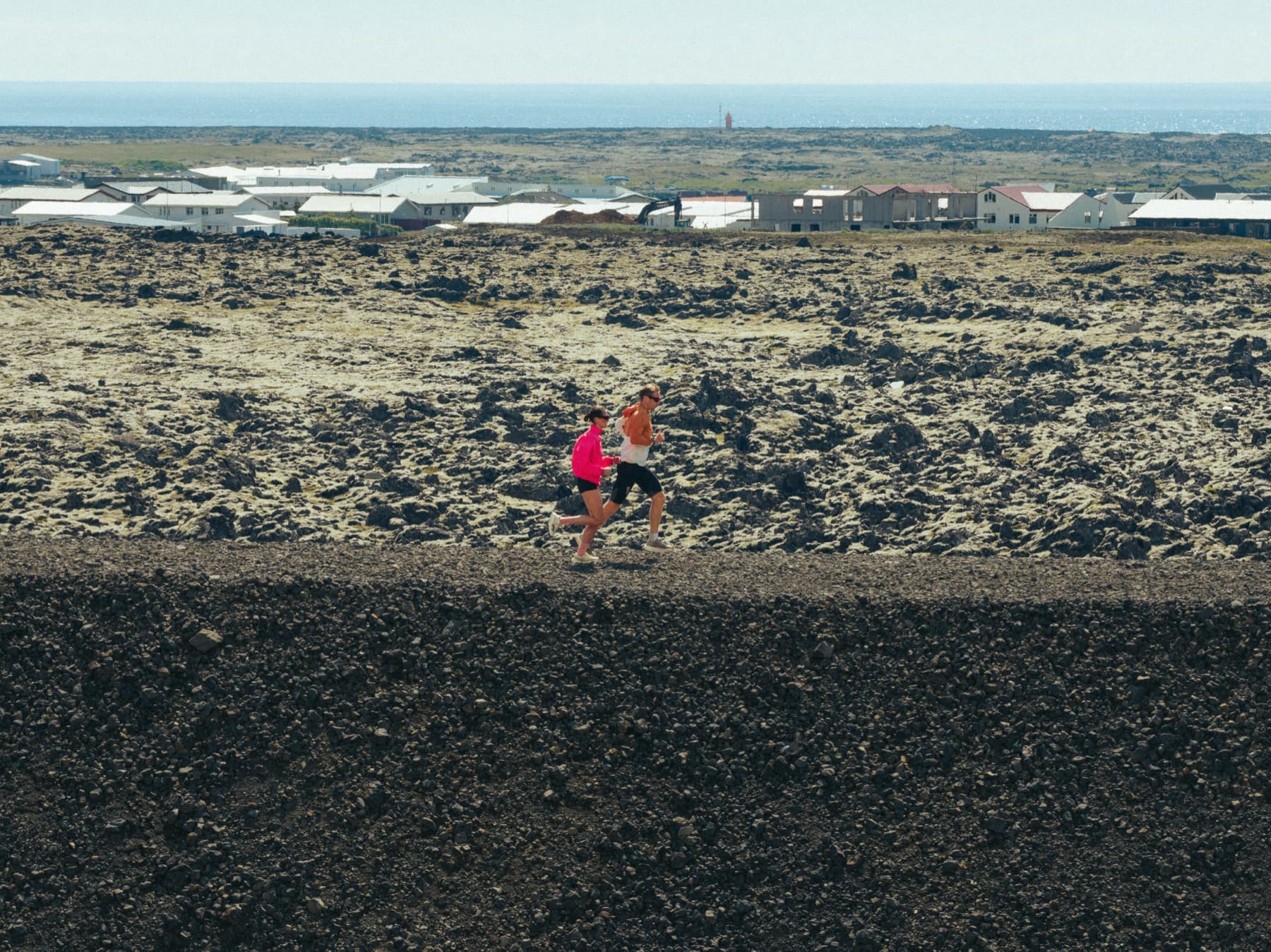 Hlauparar ofan við Grindavík með bæinn í baksýn